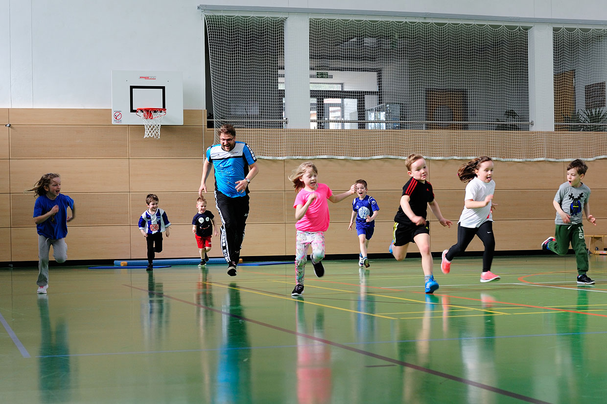 Bewegungsschule Kinder und Trainer laufen